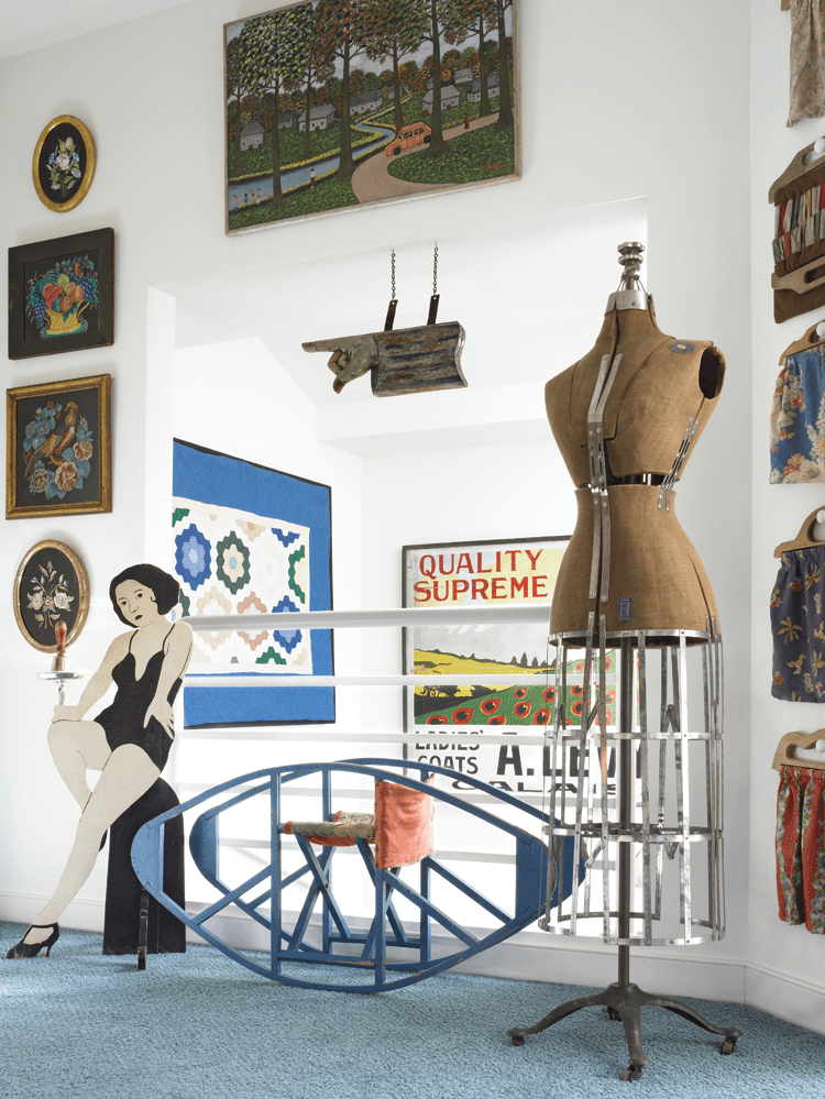 This playful space shows the open plan of the house. The assemblage of collections include an early twentieth-century bentwood child’s rocker, dress form, trade sign, tinsel paintings, knitting bags, and a naïve oil of a campsite.