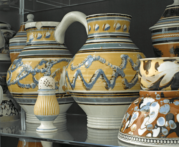 One of perhaps seven double jugs known to survive, this one is decorated with earthworm and cat’s-eye patterns. The two halves had to be constructed and decorated separately—cut at the belly and merged together with the strap handle applied, then fired.
