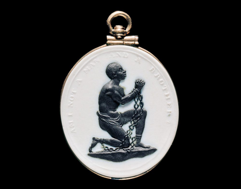 Slave-in-chains medallion by Wedgwood Manufactory, Staffordshire, England, 1786–1787. Stoneware (Jasperware), gold, 1-3/16 x 1-1/8 x 1/8 inches. Bequest of Mrs. Richard Baker (1896 96.779).