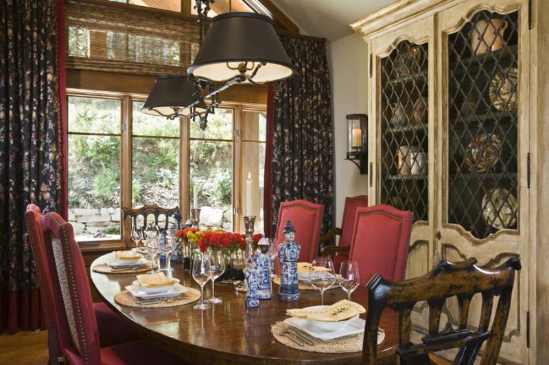 The dining room features red dining chairs with pops of animal print.