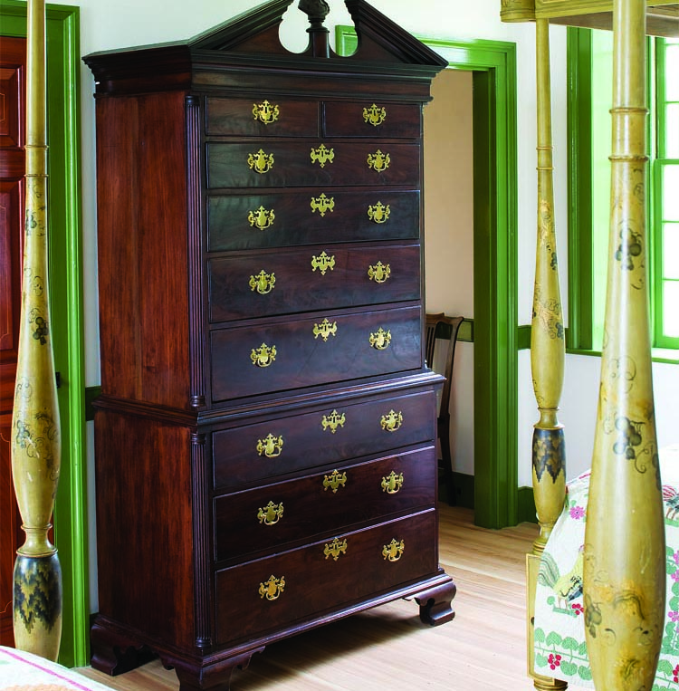 The fine detailing and proportions of this circa-1765 Philadelphia chest-on-chest is a solid representative of the Schorsch’s Chippendale period collection. The finial of John Milton is a period replacement. The circa-1820 Baltimore four-post bed (foreground) has been duplicated with a reproduction to match it on the other side of the room. The vivid grapevines on the original bed frame have been faithfully duplicated, complete with gold leaf decoration.