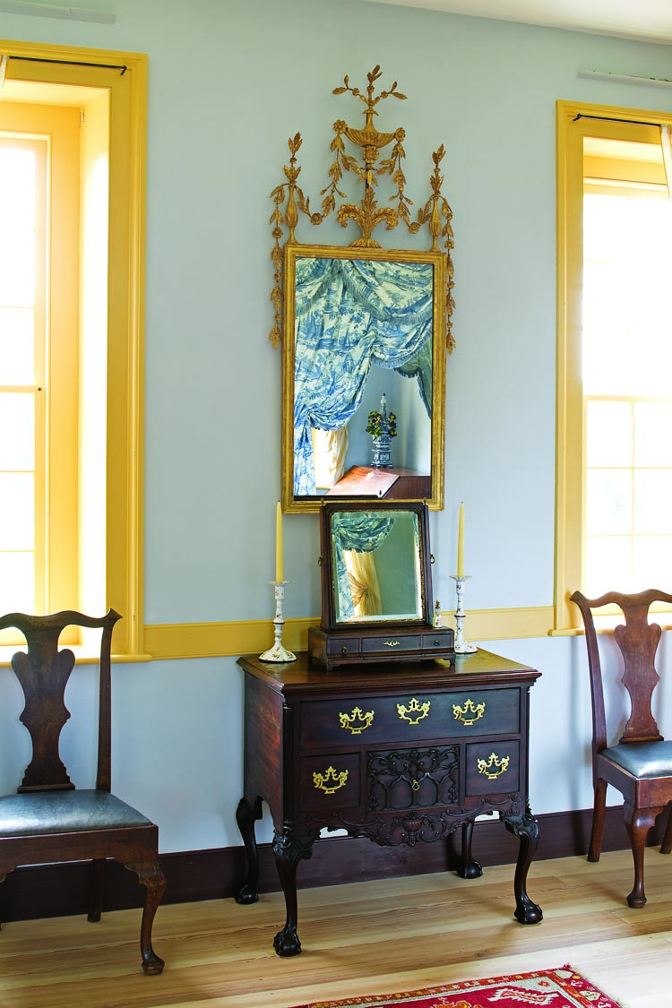 The Philadelphia circa-1770 mahogany dressing table has carving attributed to Hercules Courtenay (1744–1784). On the circa-1790 London giltwood mirror, delicate swags of vines and flowers on a central acanthus leaf base create a light and airy appearance. The pair of mahogany side chairs flanking the dressing table were probably made in Philadelphia, circa 1765.
