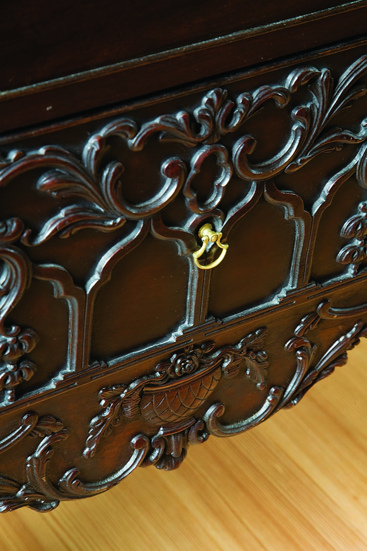 The center drawer carving of gothic arches, quatrefoil and leaf streamers, flowers, leaves, and an urn decorate the dressing table skirt.