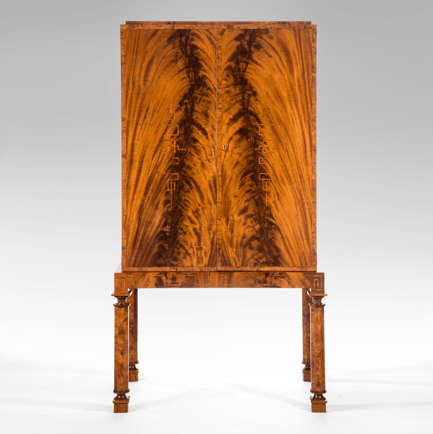 A Swedish Grace Period Flame Mahogany Cabinet on Stand, c. 1930. Offered by H.M. Luther.