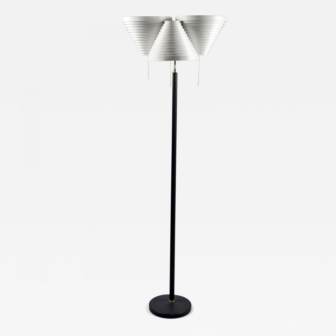 Floor lamp by Alvar Aalto, white enameled metal, three vented conical shades on a black leather sleeved brass shaft, impressed with maker’s mark, circa 1955. Offered by Bernd Goeckler Antiques.