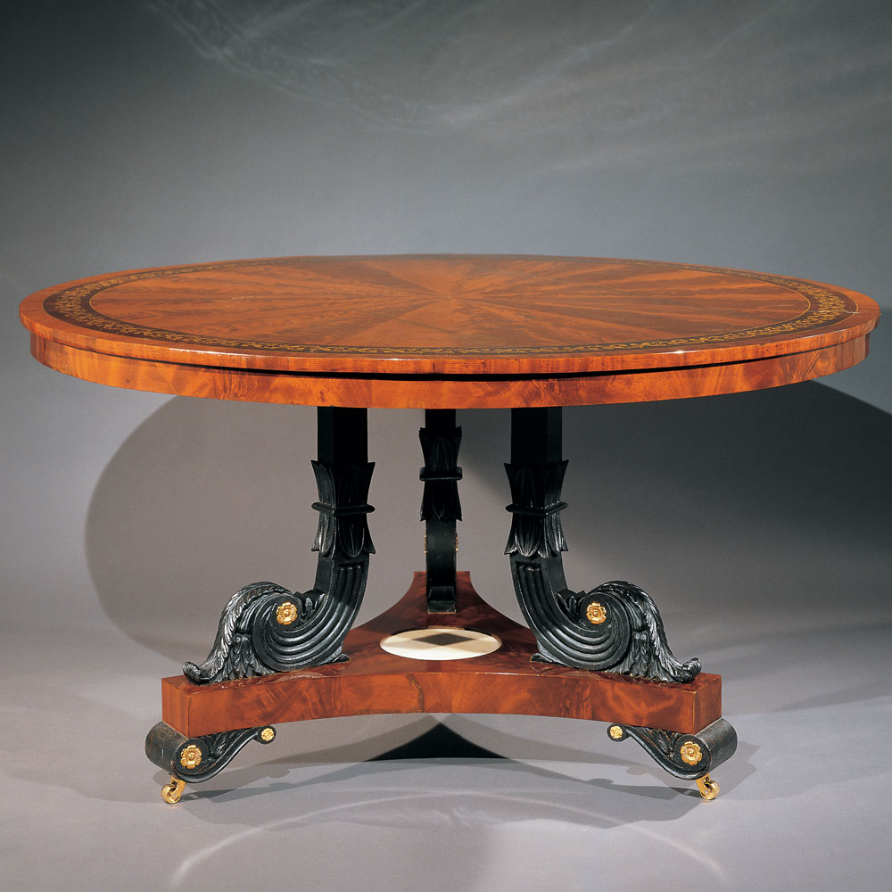 Center table, attributed to Anthony Gabriel Quervelle (born Paris, 1789, died in Philadelphia 1856), Philadelphia, circa 1825–1830. Mahogany primary with ash, mahogany, and chestnut secondary woods; verde antique paint; die-stamped brass inlay; gilt brass mounts; marble; brass and steel castors. H. 29, Diam. 54 in. Courtesy of Hirschl & Adler Galleries, New York. This magnificent center table attributed to Anthony Quervelle (1789–1856), illustrates both the wide variation of style within the context of a particular form and the high level of sophistication demanded by and available to Philadelphia patrons. This table, referred to in the period variously as a pillar and claw table or circular library table boasts superb carving treated in verde antique (painted to resemble weathered bronze like those objects excavated at Herculaneum), lacquered brass mounts, a marble inset, and spectacular radial inlaid top (which connects the piece to a drawing in Quervelle’s sketch book recently acquired by the Philadelphia Museum of Art), with an extraordinary die-cut brass foliate inlay cross banding. This style of inlay is associated in the nineteenth century with the English master cabinetmaker George Bullock and, in America, rarely found outside of Philadelphia.