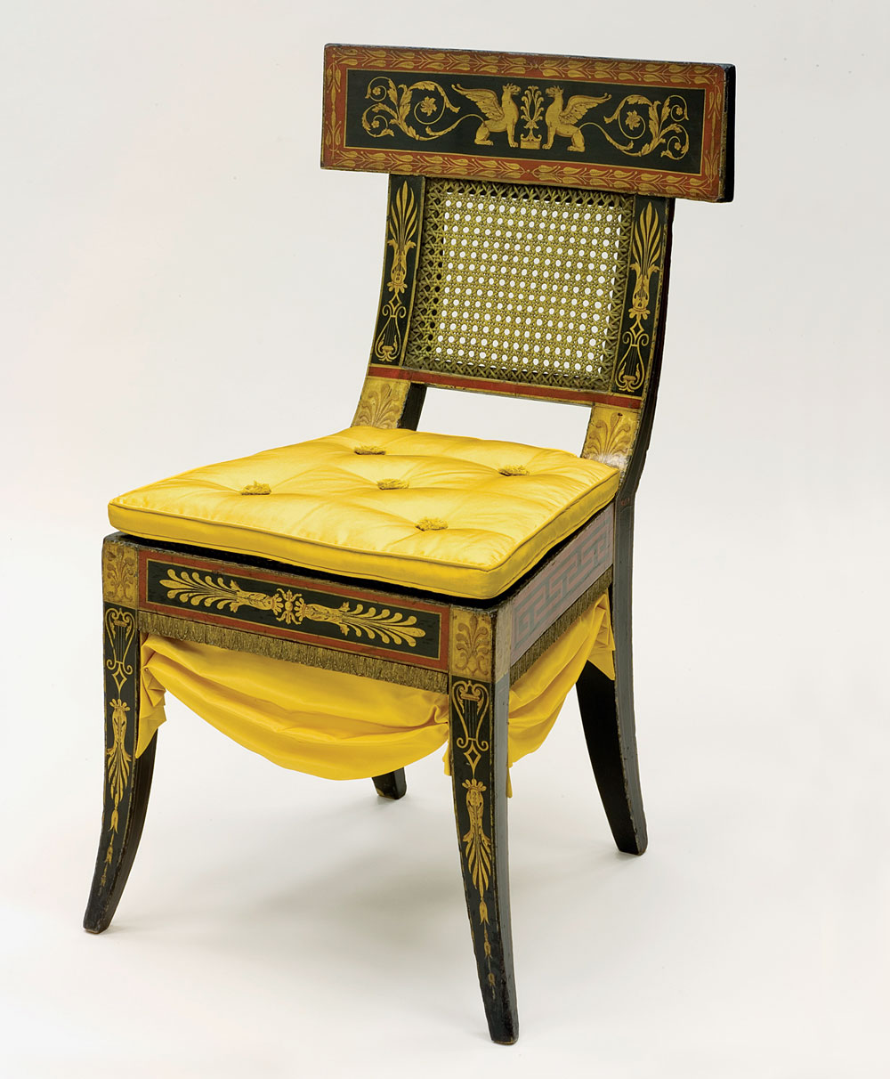 Paint decorated Klismos side chair, designed by Benjamin Henry Latrobe (1764–1820), made by Thomas Wetherill3 (d. 1824), and possibly painted by George Bridport (1783–1819), Philadelphia, circa 1808. Oak, yellow poplar, white pine, plaster composition, paint and gilding. H. 34©, 19˙, D. 22 in. Courtesy of the Philadelphia Museum of Art; gift of Marie Josephine Rozet and Rebecca Mandeville Rozet Hunt, 1935. There is no purer or more evocative furniture form in the lexicon of neo-classical furniture design than the Greek Klismos chair. Klismos chairs were found painted on Greek vases unearthed in southern Italy throughout the eighteenth century, and seen in wall paintings excavated at Herculaneum and Pompeii.4 As the quintessential expression of Greek furniture design, interpretations were published by every important furniture designer of the first half of the nineteenth century. With its curving tablet crest rail extending beyond the rear stiles and front and rear saber legs, it represented not just a radical departure from rococo furniture popular only twenty years earlier, but a complete departure from the neoclassicism of Adam and Hepplewhite, and designs from Sheraton’s Drawing Book, known here as Federal furniture. The Klismos chairs designed by Latrobe in 1808 for William Waln, of which fifteen have survived (one is illustrated here) are among the earliest documented Klismos style chairs made in the United States. It is most likely that Latrobe was inspired in his design from Thomas Hope’s Household Furniture and Interior Decoration (London, 1807), the influential classically-inspired pattern book of the English Regency. The early date of these chairs reminds us that the United States was no longer a colonial backwater but fully in-step with Western fashion. The Waln suite of furniture is as high-style and avant-garde as anything produced in London or Paris at the same date.