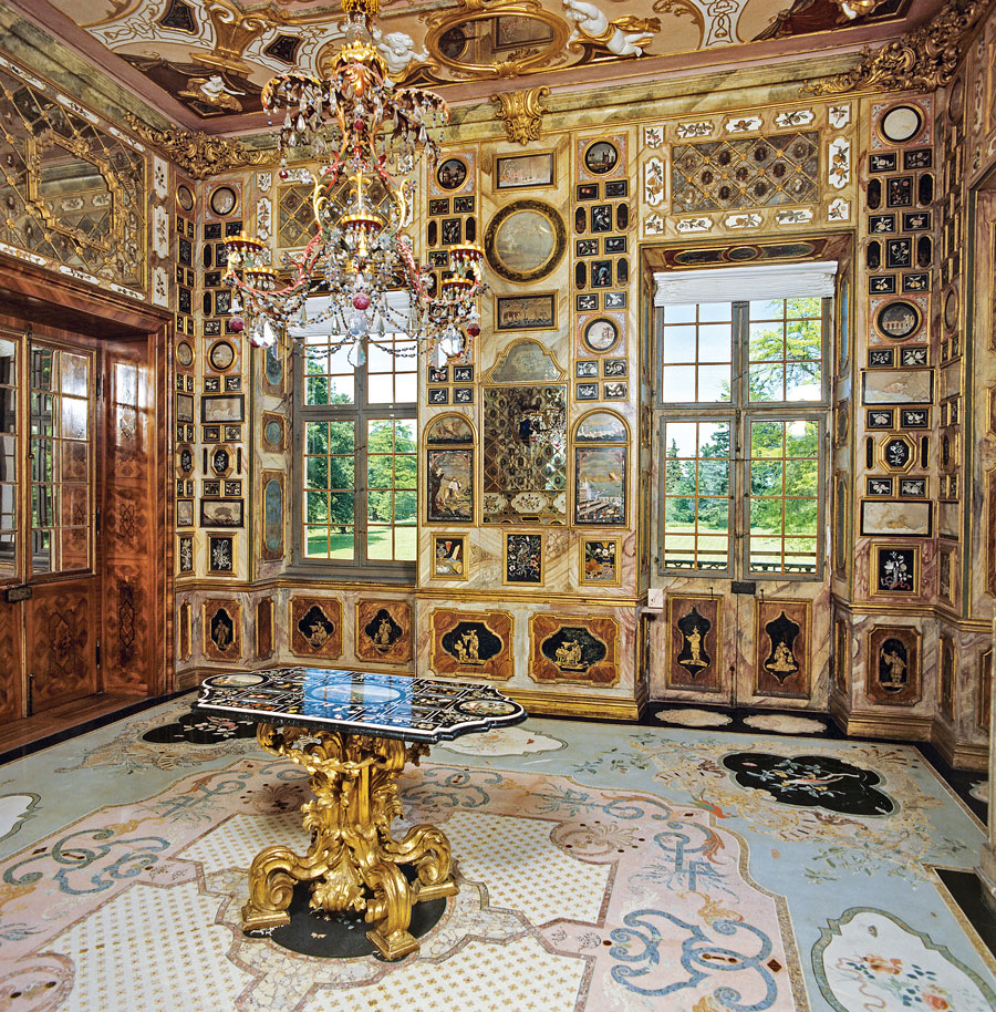 Fig. 16: Florentine Cabinet in the apartment of the Crown Prince. This breathtaking room is still in its original condition and the only one of its kind in Europe. The 758 Pietra Dura panels were crafted from marble, granite, and semiprecious stones in the Grand Ducal workshops in Florence. They cover the walls in a kaleidoscope of color. Sibylla Augusta was probably able to acquire the panels because of her close kinship with the House of Medici. The splendid chandelier (the counterpart hangs in the Mirror Cabinet opposite), counts as one of the most important Bohemian chandeliers to have survived from the early-eighteenth century. Photography by Landesmedienzentrum Baden-Wuerttemberg.