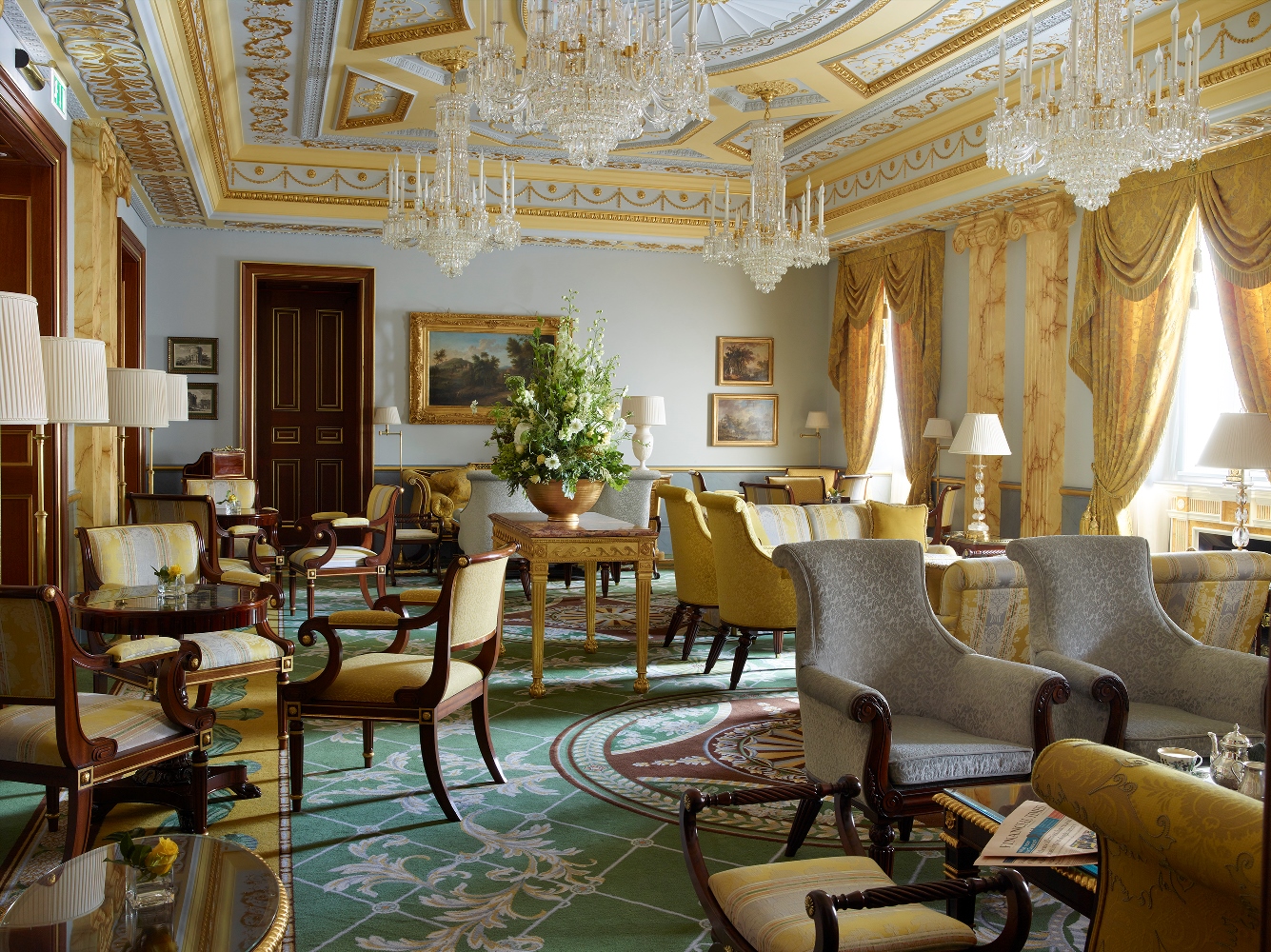 The Lanesborough's Withdrawing Room features hand-painted trompe l’oeil marbling, a quartet of Wilkinson chandeliers, sumptuously upholstered, high-sided armchairs and sofas, and a beautiful central fireplace.