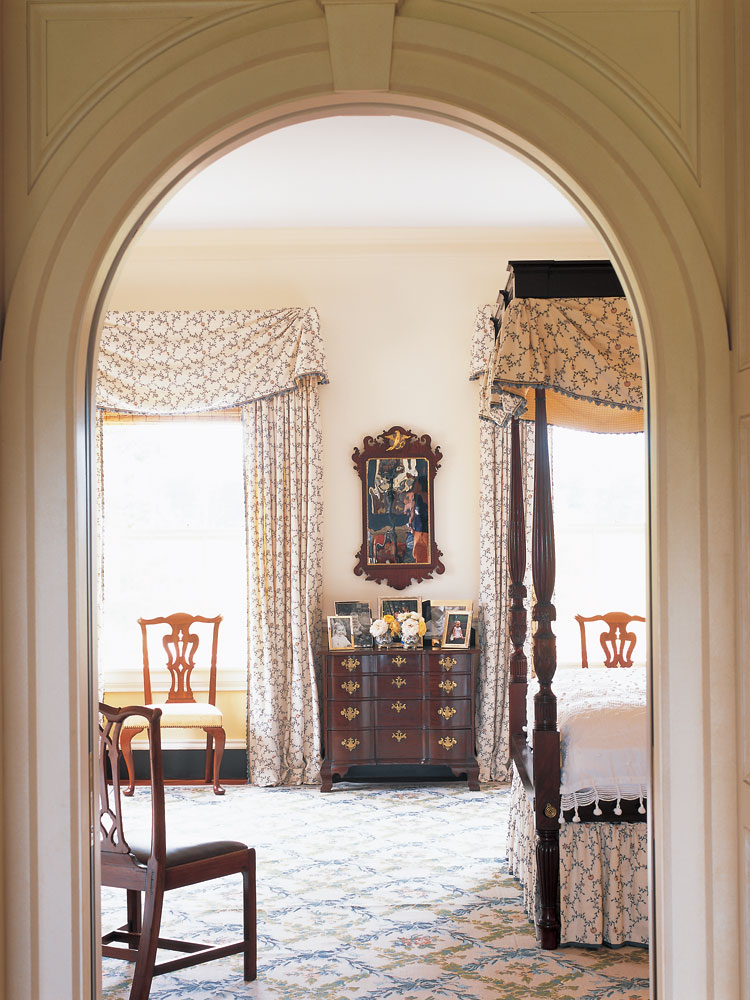 The high post bedstead in the master chamber was made in Salem, Massachusetts, and has carving related to that of Samuel McIntire; the tester is modern. Against the pier wall is a diminutive rounded block-front chest of drawers from Salem or Boston, with original pulls.