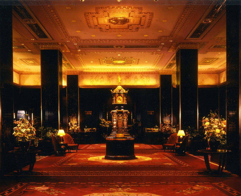 The Waldorf main lobby, with clock, marble columns, and ceiling details are all indicative of the Art Deco design. Image courtesy of Host to the World.