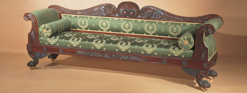 Classical carved mahogany sofa, possibly Anthony G. Quervelle (1789–1856; active 1817–1856), Philadelphia, circa 1825–1830. Mahogany; mahogany, pine, and tulip poplar secondary woods; caned seat with upholstered slip seat; gilt-brass castors. H. 35˚, L. 96©, D. 23µ in. Courtesy of Hirschl & Adler Galleries, New York. Another evocation of ancient Greece and Rome was the scroll-arm sofa inspired by the fulcrum-ended beds used then for reclining while dining. This monumental Philadelphia example exhibits characteristic acanthus leaf carving and a shell design now associated with Quervelle through the recent discovery of his sketchbook in the collection of the Philadelphia Museum. The seat rail conjures Greek architecture with the rosettes and metopes of a Doric frieze terminating with palmette acroteria. The crest rail and animal feet are part of the ubiquitous classical vocabulary that might have been gleaned from Piranesi. The sofa’s design may have been influenced by a settee illustrated in Thomas Hope’s Household Furniture (London, 1807), plate XVIII, No.5.