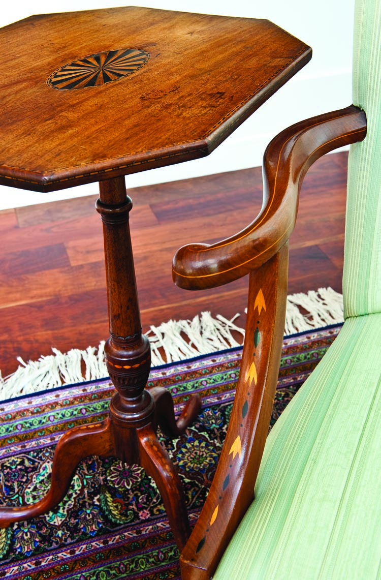 Detail of the inlay and craftsmanship on a candlestand and lolling chair in the east end of the great room.