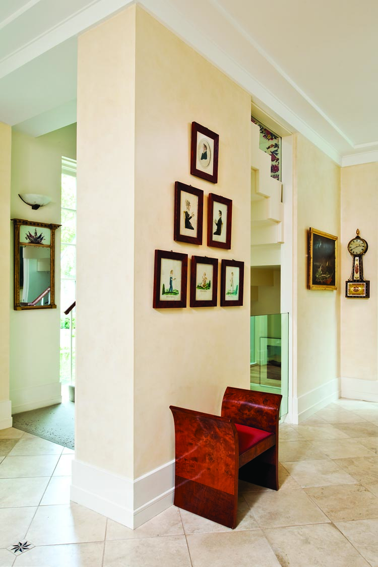 Around the corner from the foyer is a group of watercolor portraits by Jacob Maentel (1763–1863) of six members of the Musser family of Reamstown, Lancaster County, Pennsylvania, painted on October 23, 1826. The sitters are George, his wife, Elizabeth (Sweitzer), and children Sarah, Edward, and Carolina in three-quarter and full-length portraits, shown with yellow-decorated chairs or in landscapes. An earlier portrait of the children’s grandfather hangs among them. This group is a rare intact family group of portraits by the artist, and shows how Maentel conceptually organized a large group of figures, giving each age its own style of setting and pose. The collectors also own the inscribed Musser family record. Beyond the Maentels, the banjo clock on the far wall, signed “Simon Willard & sons #4327,” retains its decorated original eglomisé panels. Beside it, a Thomas Chambers painting of the shipwreck of the Bristol off Rockaway Beach, New York, is one of two Chambers sea scenes in the collection. The wife comments that when her son saw their first Chambers painting he said, “You finally bought something I like!”
