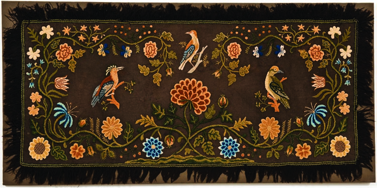 Also in the master bedroom is one of the few nineteenth-century American rugs by a known maker. Marcy Huntting of East Hampton, Long Island, made this rug circa 1810. In shades of crewel yarns embroidered onto a wool twill ground, the design is reminiscent of eighteenth- century bed hangings and bed rugs. The interest in exotics is evidenced in the Hoopoe bird taken from an early publication of bird engravings.