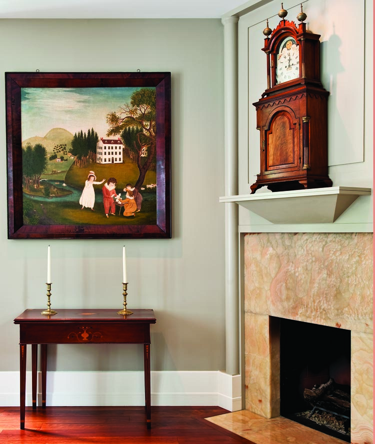 The large painting above the card table, by an unidentified artist, at the fireplace end of the husband’s study is an early example of a fully developed folk art landscape painting, circa 1810–1820. Below the painting is a rare Federal card table attributed to Nathan Lombard of Sutton, Mass. (A table of similar form is in the Garvin collection at Yale.) The shelf clock on the mantel is signed by John Bailey of Hanover, Mass, and the rear of the moon-phase dial is signed “J. Minott 1793,” regarded as one of the best Federal-era dial painters. Made to appear as a clock sitting on a separate base, both sections have brass, stop-fluted columns, ogee bases, and the lower case features an applied scrolled molding and deeply-carved paneled door.